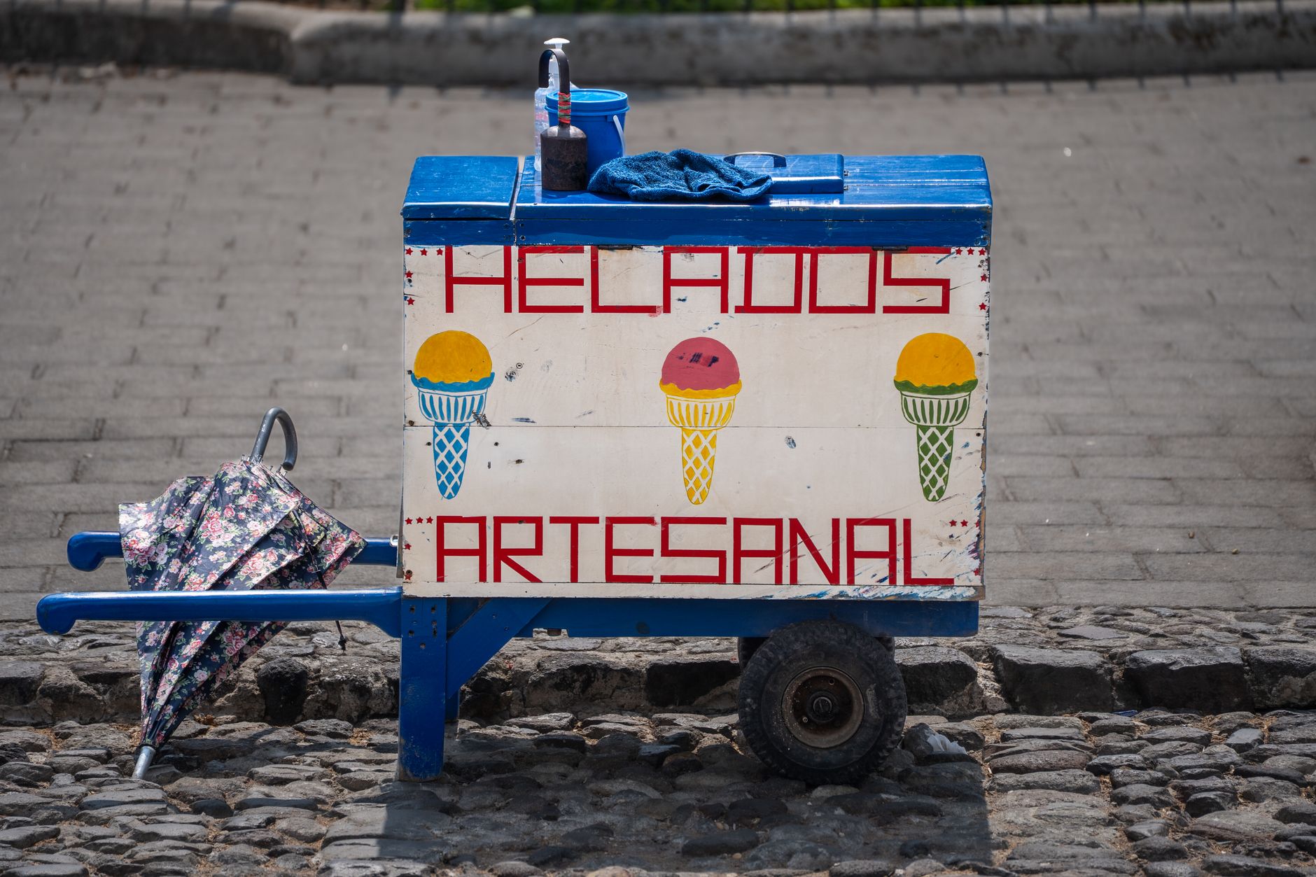 Mostrador de la nevería con botes de nieve de colores y conos listos al frente